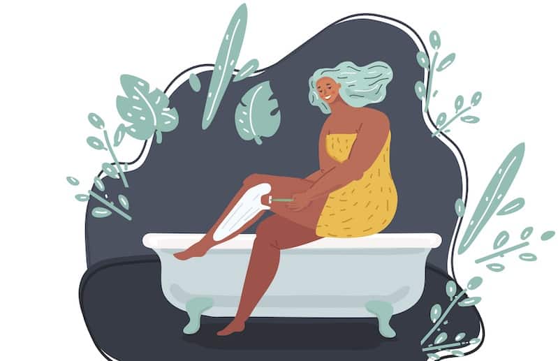 woman shaving her legs in the bath tub